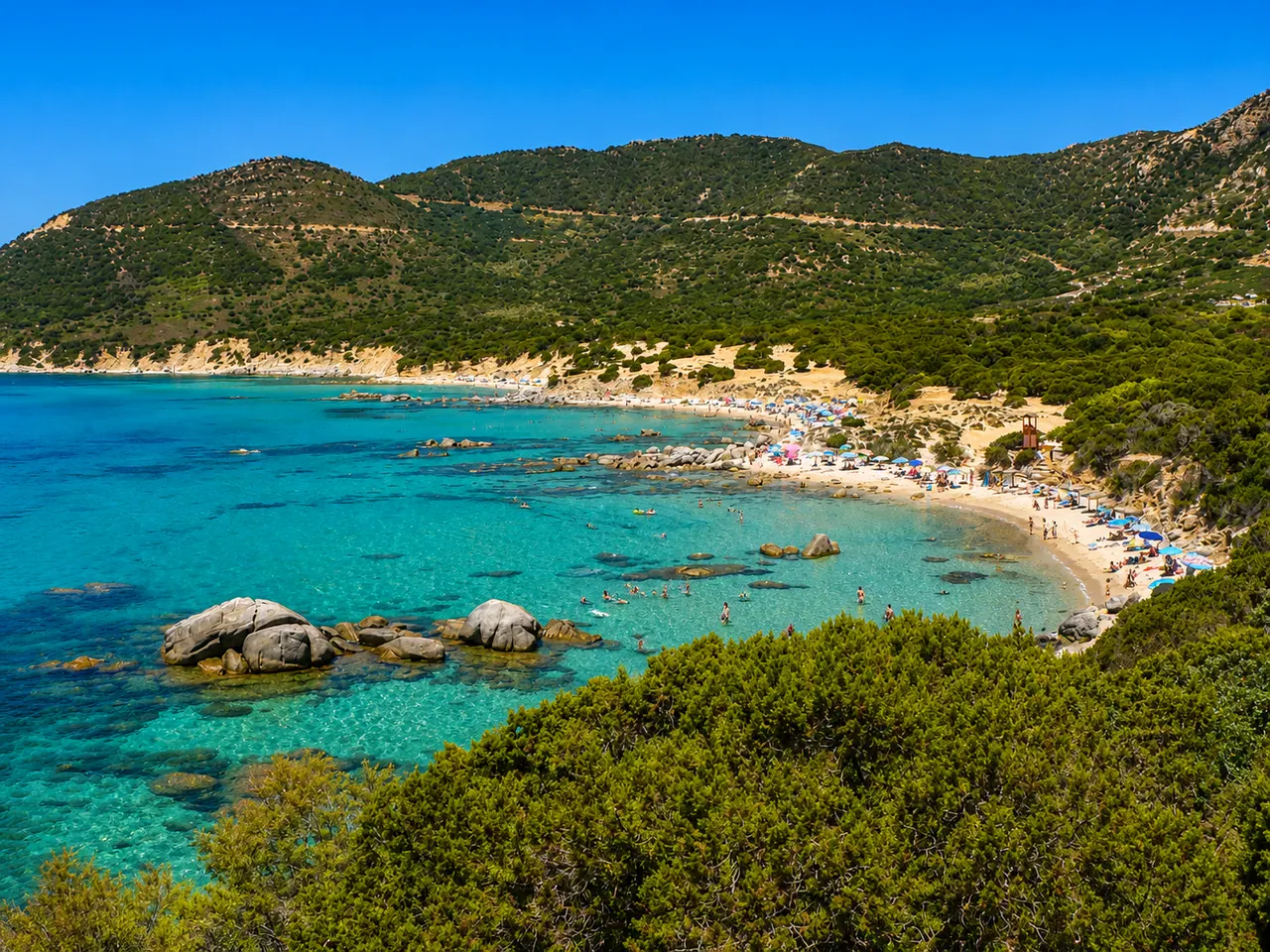 Campus, Villasimius — cala con grandi massi granitici, sabbia chiara, ginepri e acqua turchese cristallina