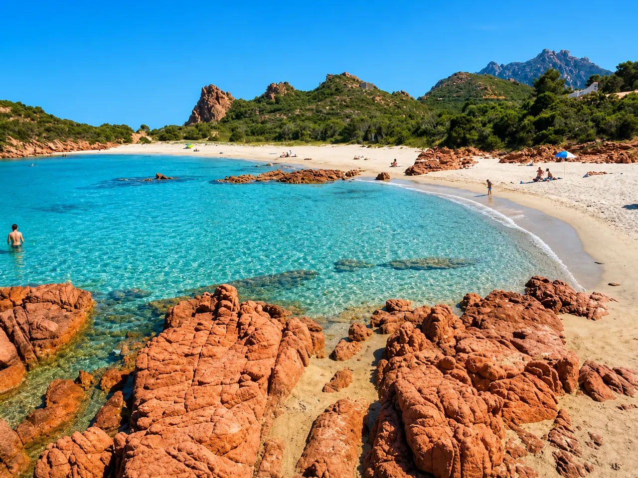 Su Sirboni, Tertenia — cala selvaggia con rocce di porfido rosso, sabbia chiara e acqua turchese cristallina